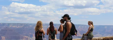 eine Gruppe junger Menschen steht vor dem Grand Canyon. Eine Frau trägt einen CGM-Sensor