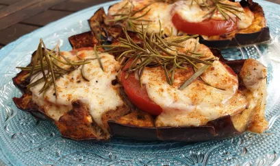 Auberginen mit Tomate-Mozzarella überbacken und Rosmarin dekoriert.