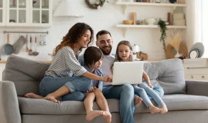 Familie sitzt vor einem Laptop